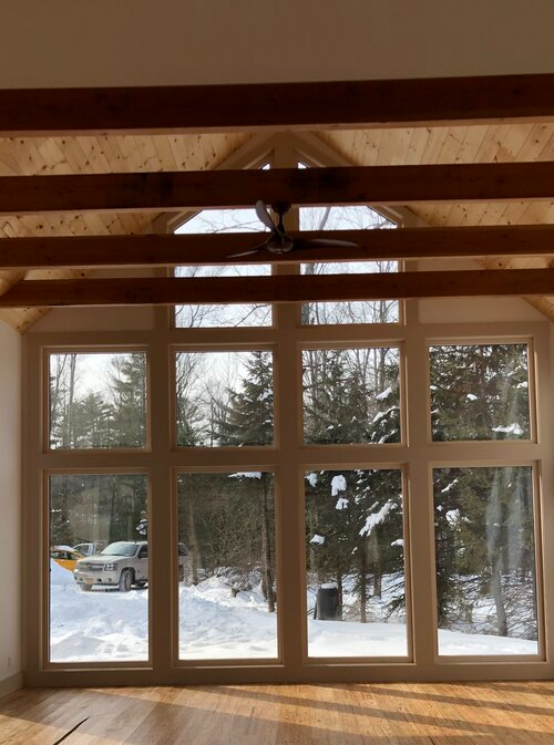 A room with a lot of windows and a ceiling fan