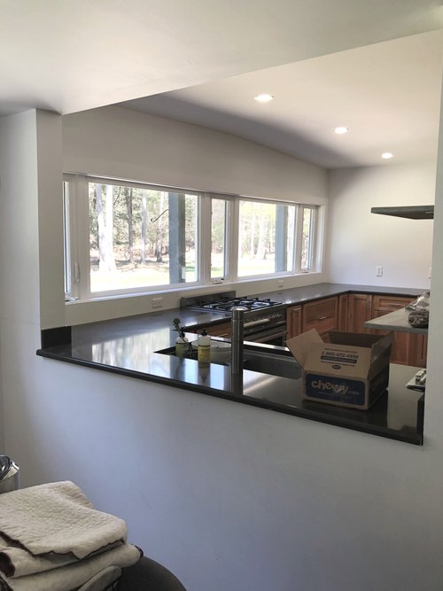 A kitchen with a lot of windows and a box on the counter.