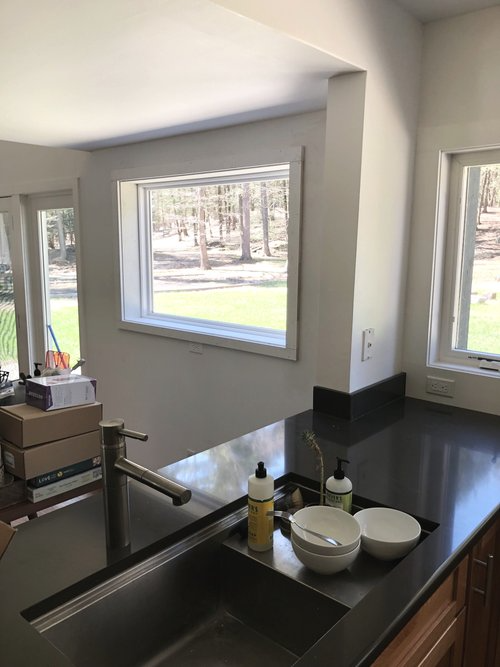 A kitchen with a stainless steel sink and a window.