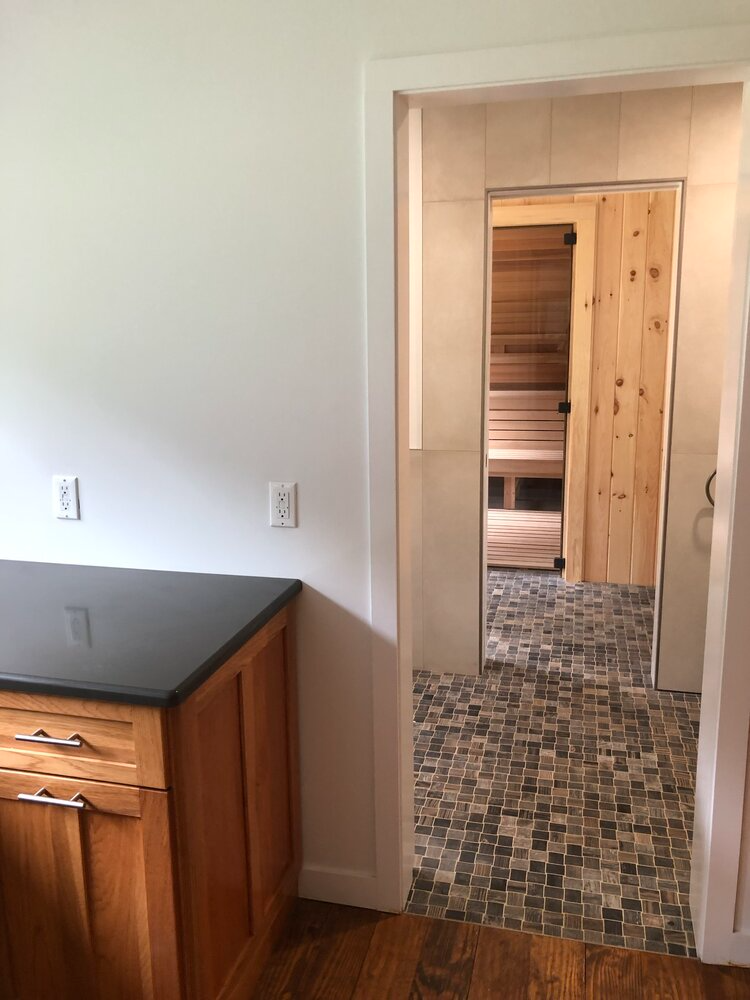 A doorway leading to a bathroom with a wooden door