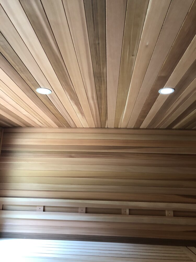 A wooden sauna with a wooden ceiling and walls.