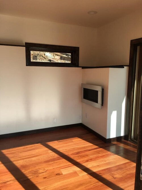 A living room with hardwood floors and white walls