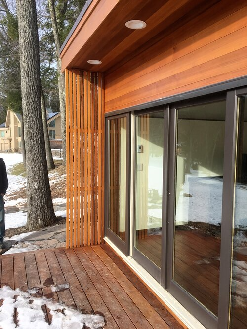 A house with sliding glass doors and a wooden deck