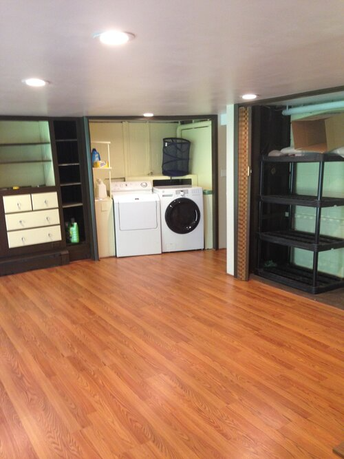 A laundry room with hardwood floors and a washer and dryer
