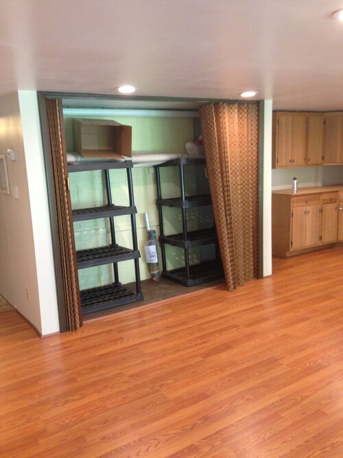 A room with hardwood floors and shelves in it.
