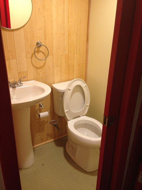 A bathroom with a toilet a sink and a mirror