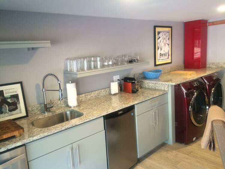 A kitchen with a sink and a washer and dryer
