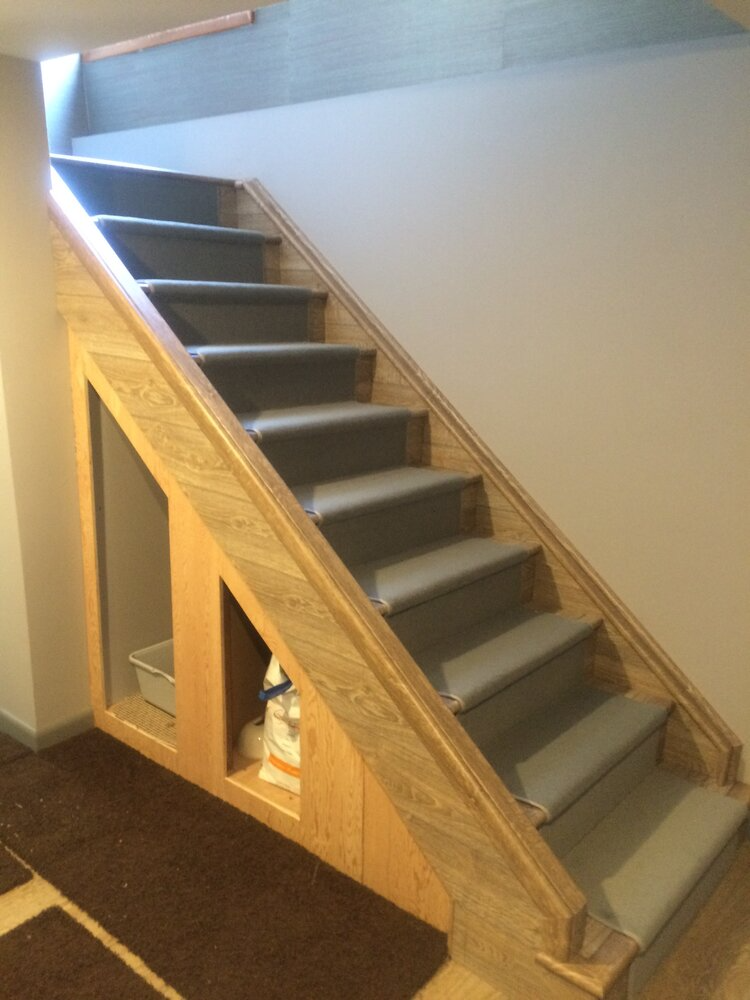 A staircase with a shelf underneath it