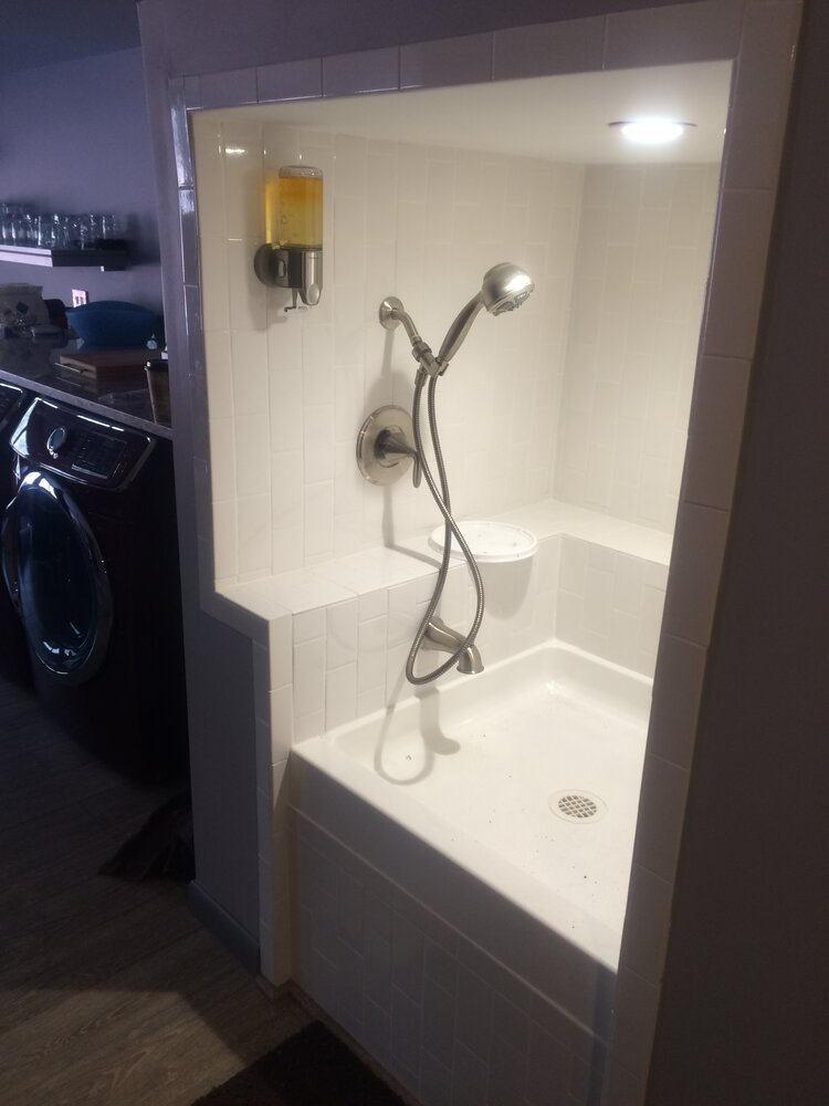 A bathroom with a shower and a washing machine