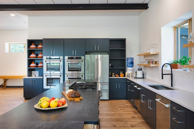 A kitchen with stainless steel appliances and black cabinets