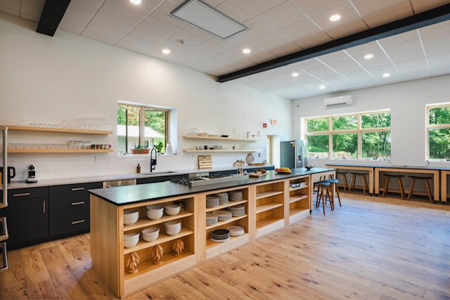 A large kitchen with a lot of shelves and stools.