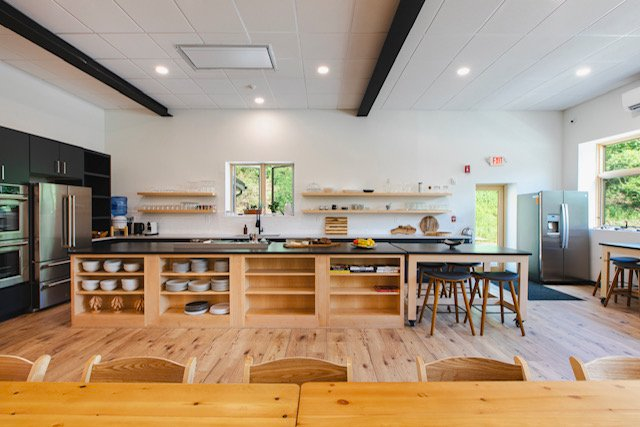 A large kitchen with a table and chairs in it.