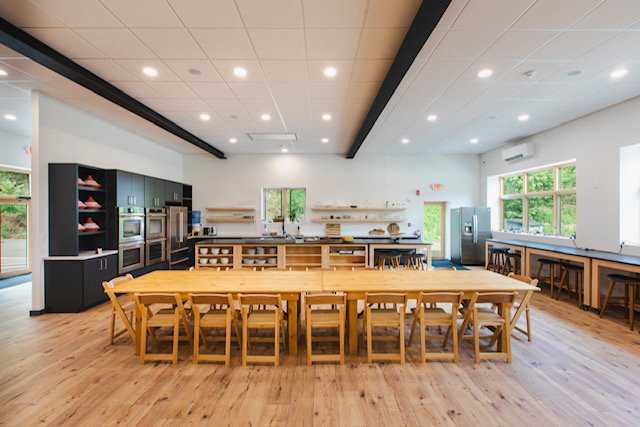 A large room with a long table and chairs in it.