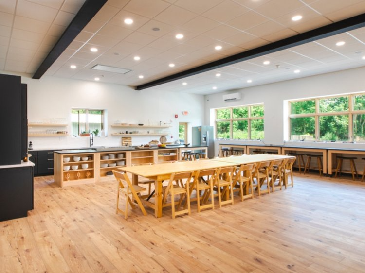 A large room with a long table and chairs in it.