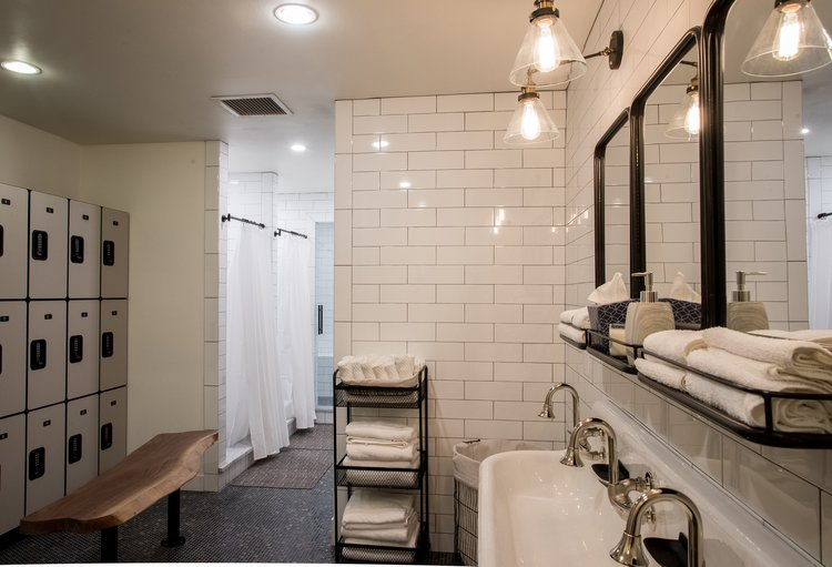 A bathroom with a sink , mirrors and lockers