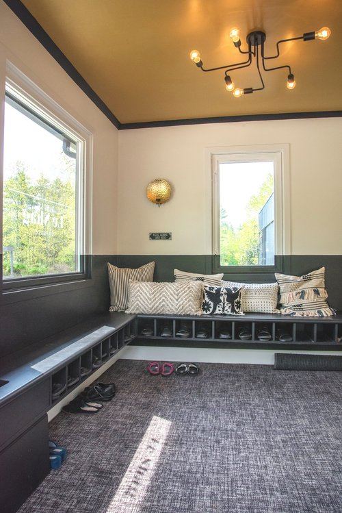 There is a bench in the middle of the room with a chandelier hanging from the ceiling.