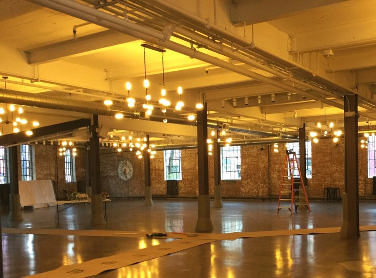 A large empty room with a lot of lights hanging from the ceiling.