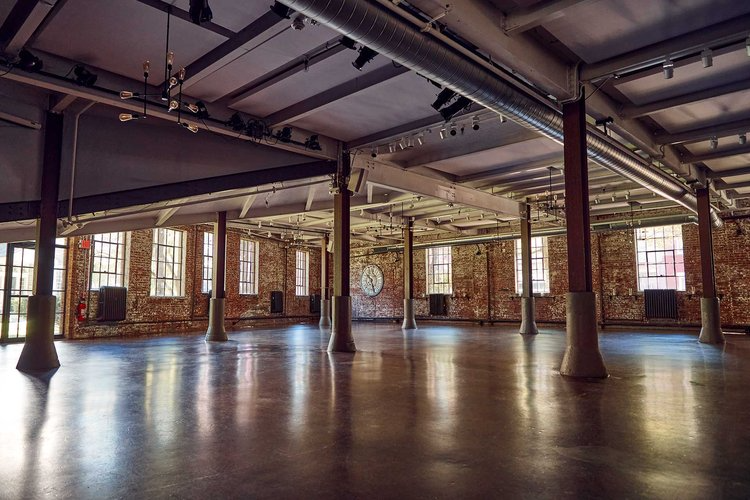 A large empty room with a lot of windows and columns.
