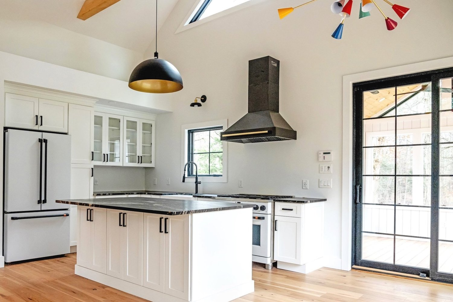 A kitchen with white cabinets , stainless steel appliances , and a large island.
