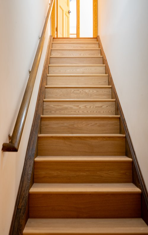 A set of wooden stairs leading up to a door.