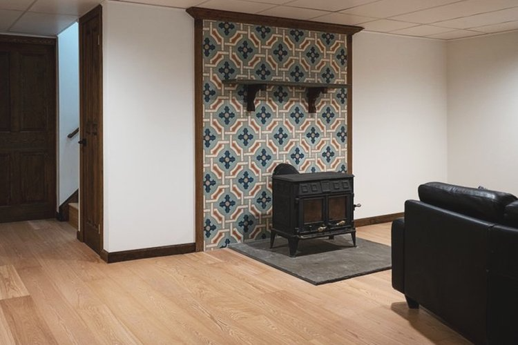 A living room with a wood stove and a couch.