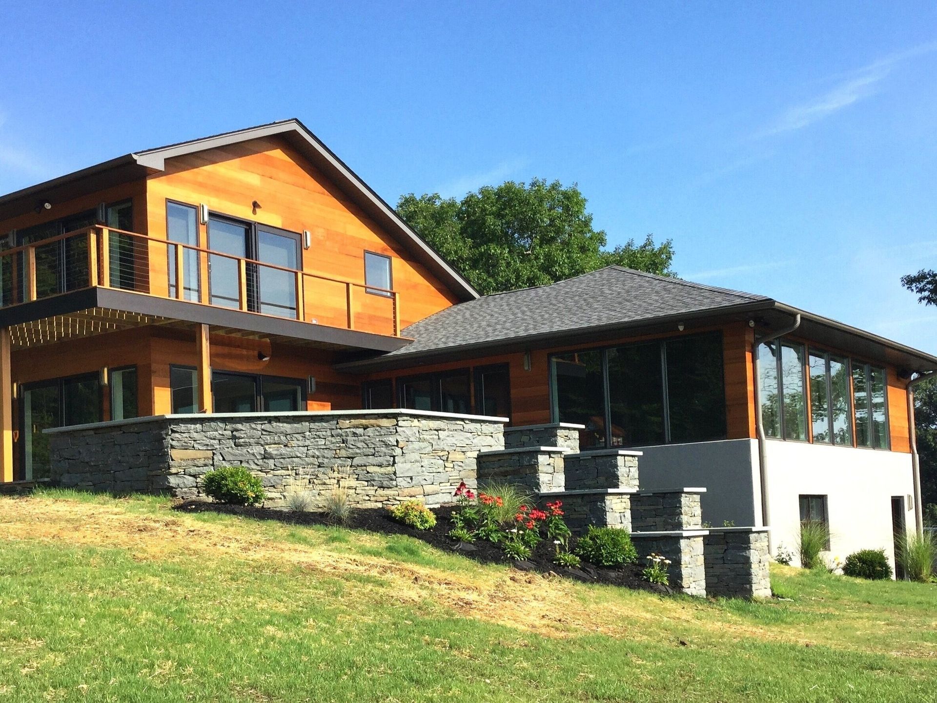 A large house is sitting on top of a grassy hill
