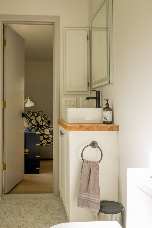A bathroom with a sink , toilet and mirror.
