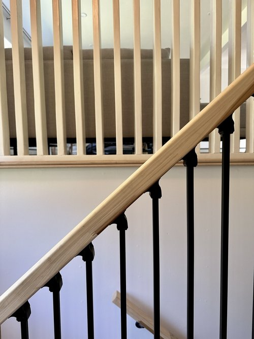 A staircase with a wooden railing and black railing