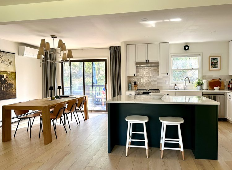 A kitchen with a table and chairs and a large island in the middle of the room.