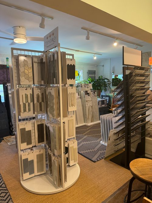 A display of tiles in a store with a stool in the foreground.