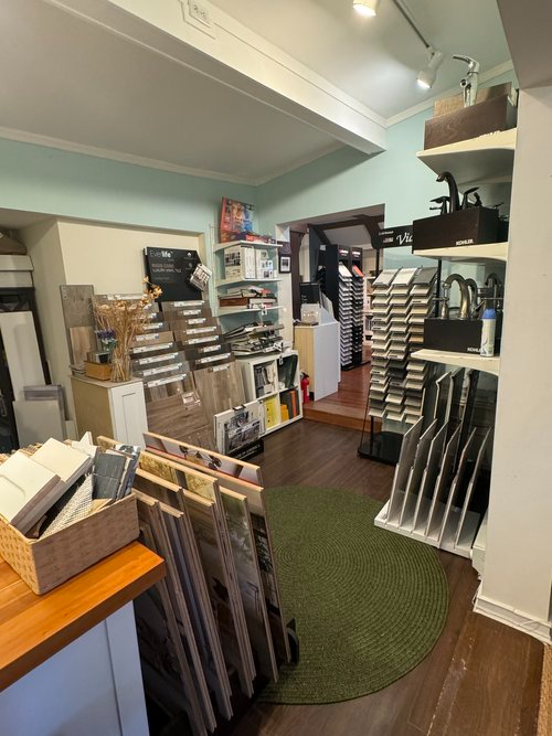 A room with a lot of shelves and a rug on the floor.
