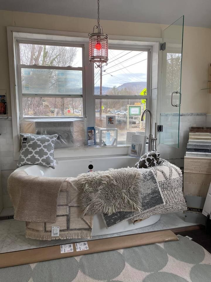 A bathroom with a tub sitting in front of a window.