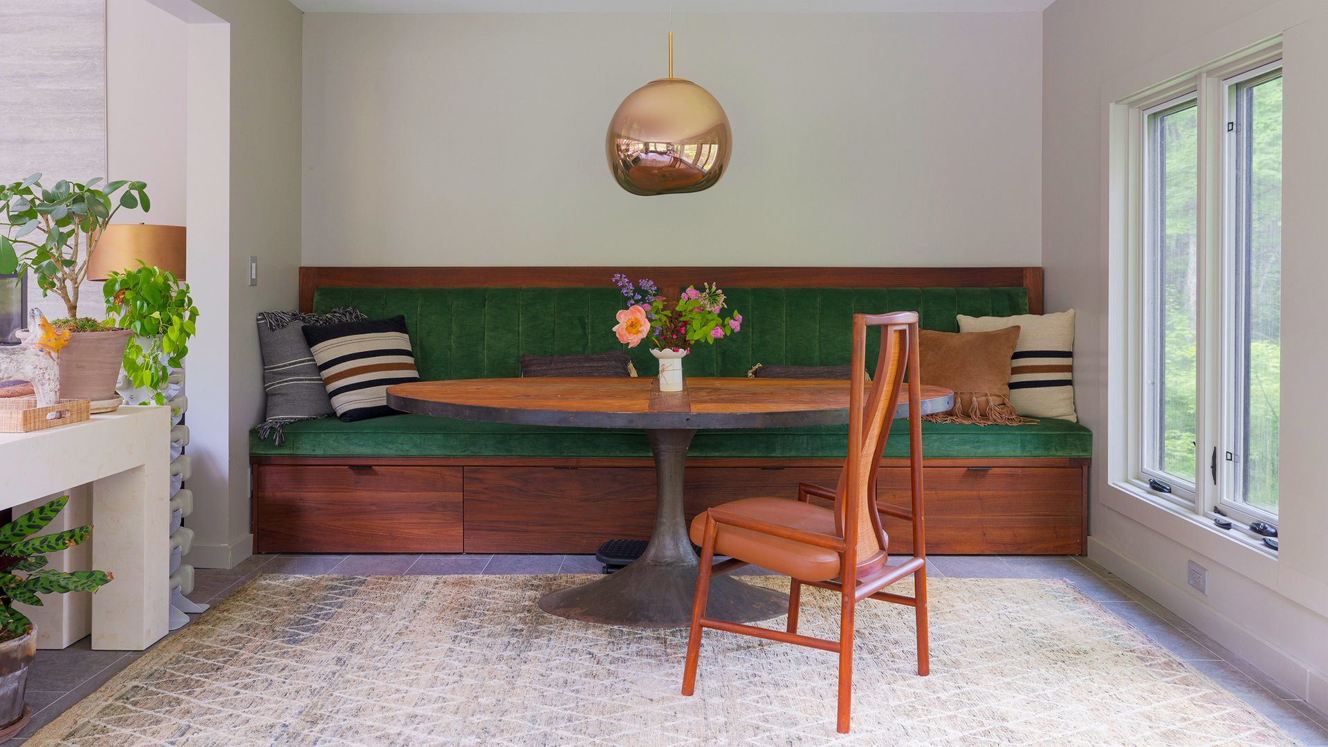 A green velvet banquette seat with wooden storage