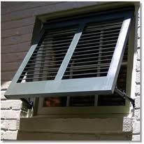 A window with shutters open on a brick wall.