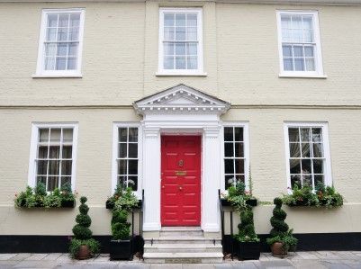 A white house with a red door and white windows