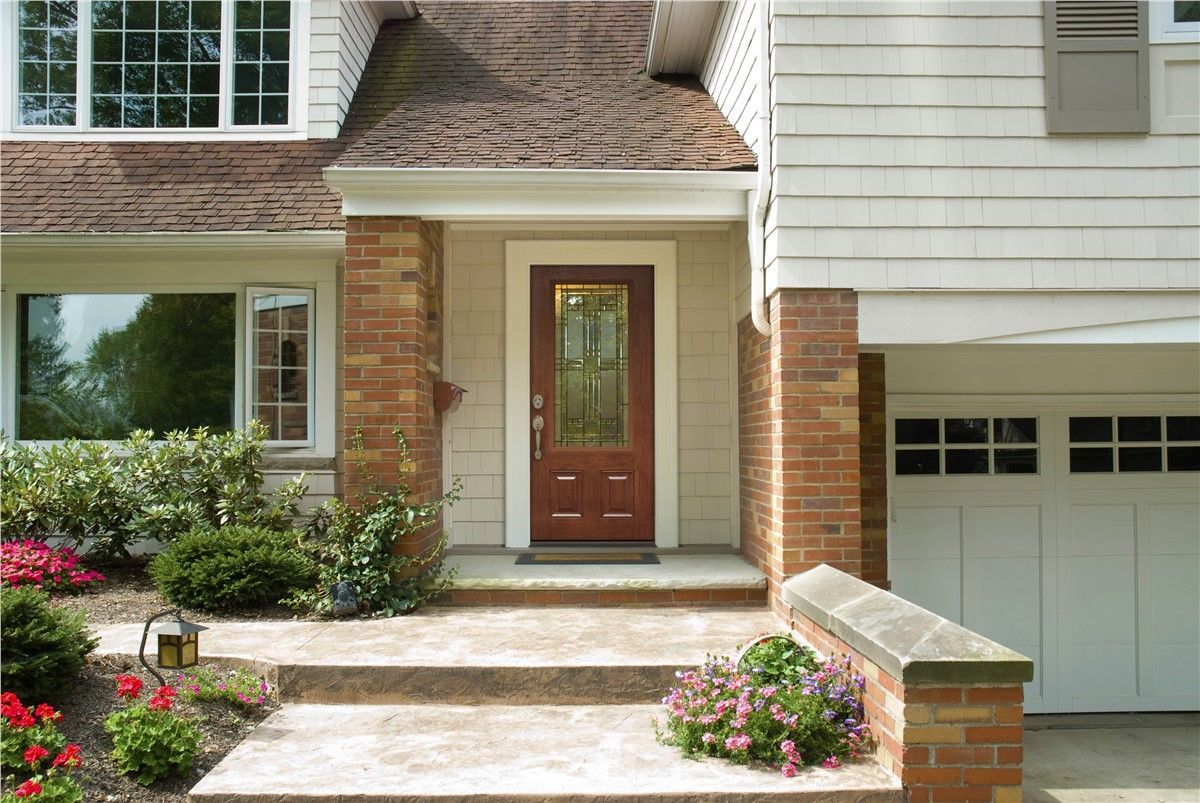 A house with a brown door and a white garage door