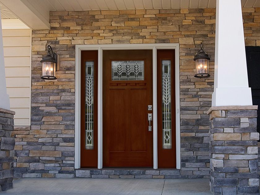 The front door of a house with a stone wall