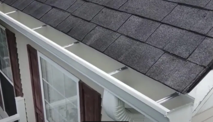 A gutter on the side of a house with a roof.