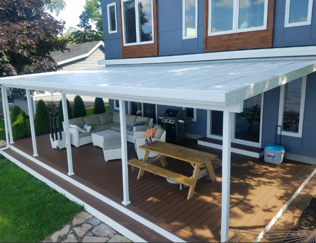 A covered deck with a picnic table and a couch