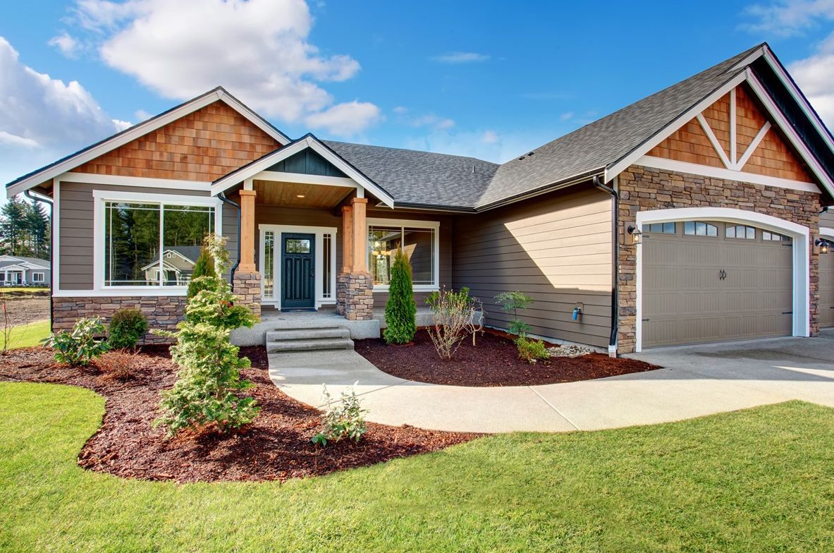 A large house with a large garage and a driveway in front of it.