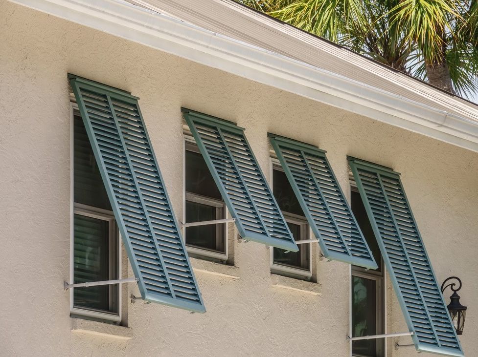 A white house with blue shutters on the windows.