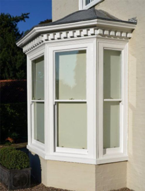 A white bay window on the side of a house.
