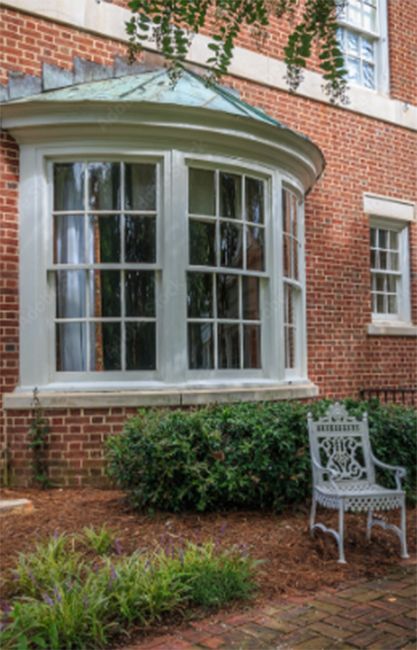 A curved window on the side of a brick building.