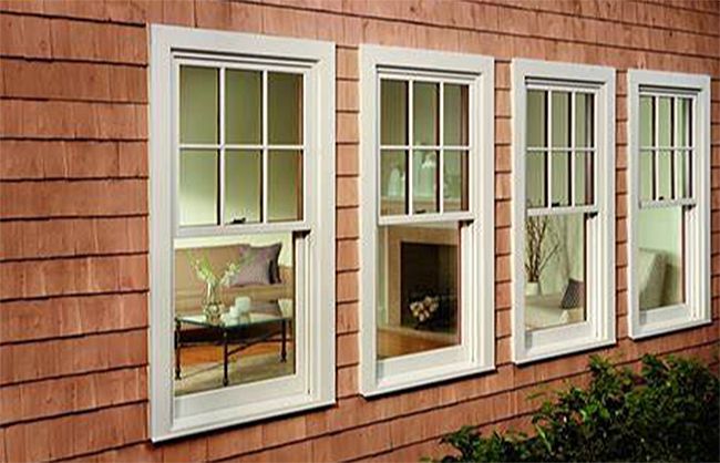 A row of white windows on a brick building.