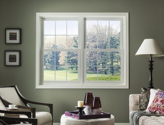 A living room with a couch and chairs and a large window.