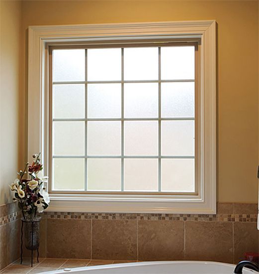 A bathroom with a large window and a tub.