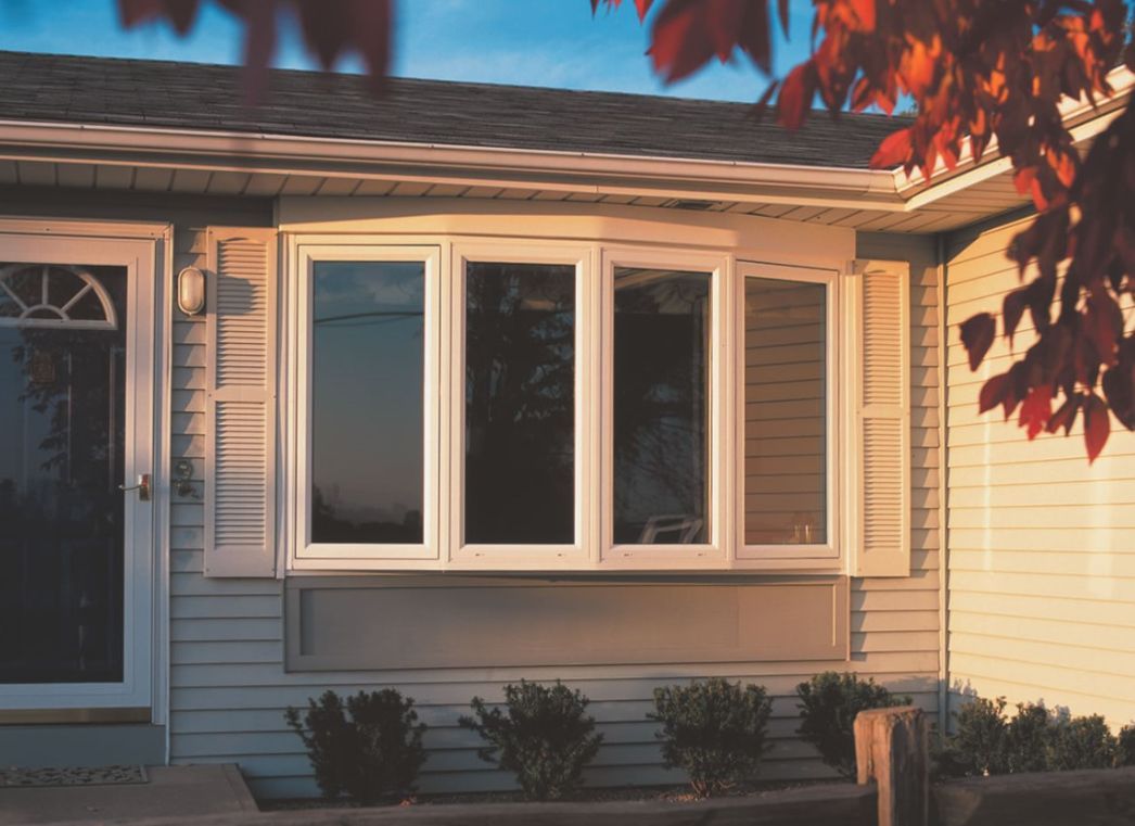 A white house with a large window and a door.