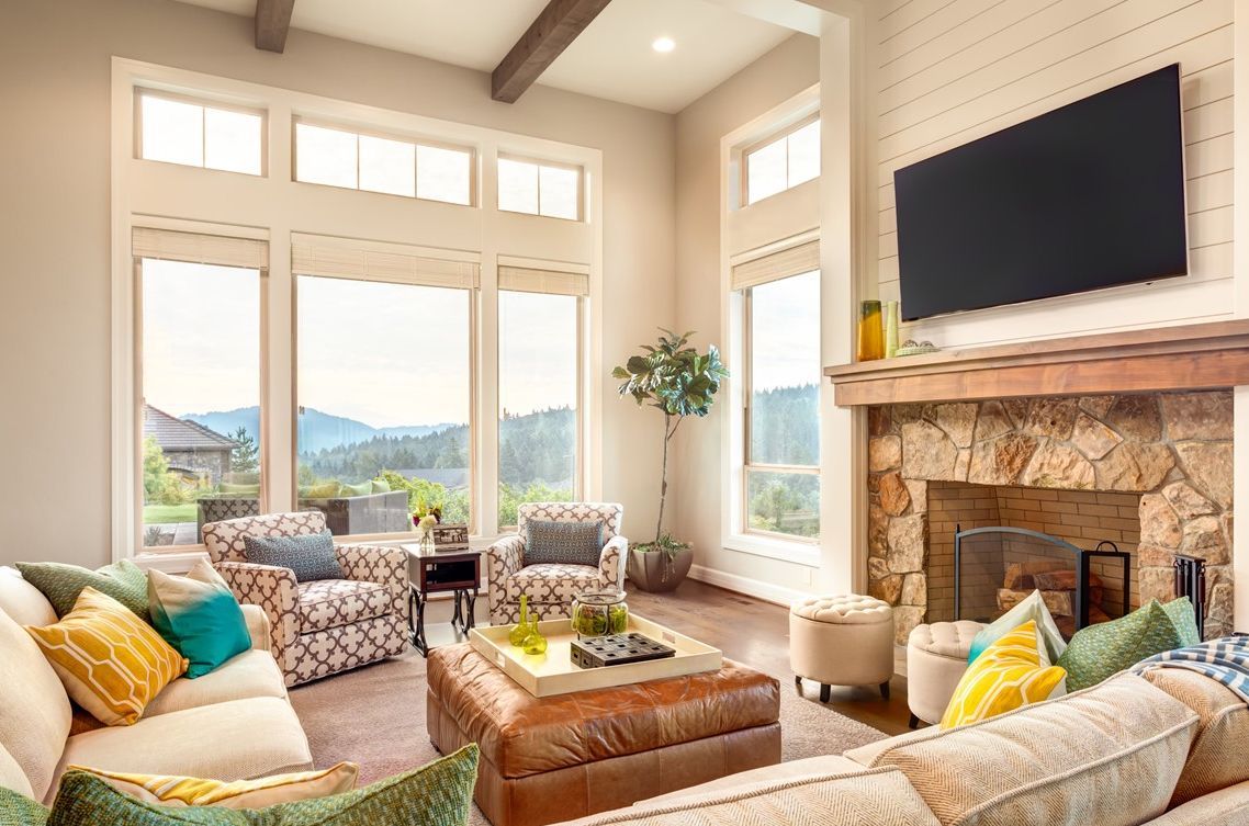 A living room with a couch, chairs, fireplace, and television.