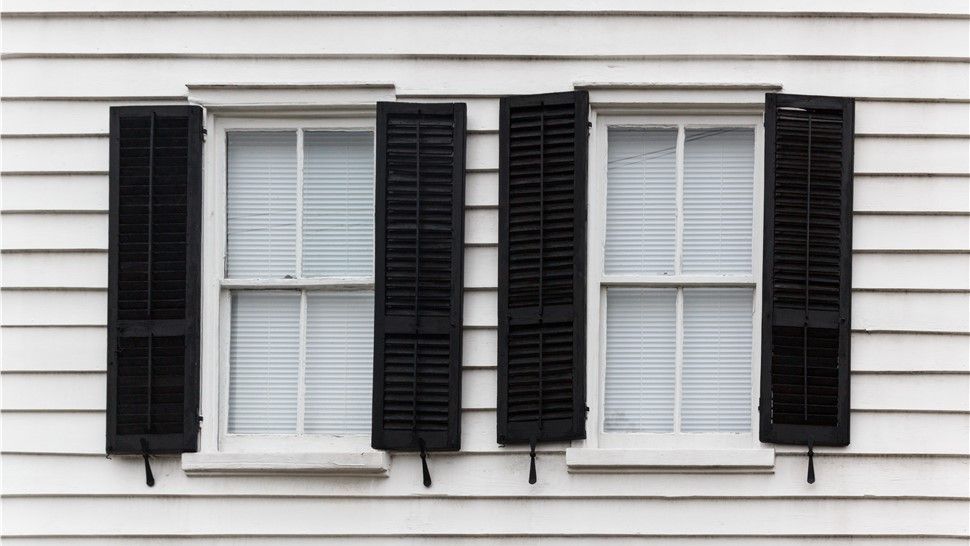 A white house with black shutters on the windows