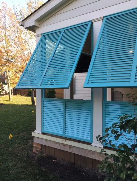 A white house with blue shutters on the porch
